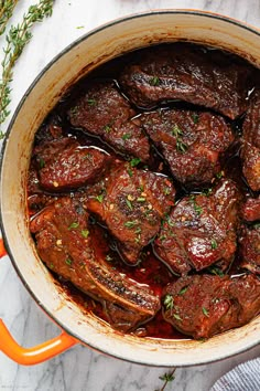 a pot filled with meat and sauce on top of a table