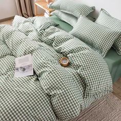 a green and white checkered comforter set on a bed with two pillows next to it