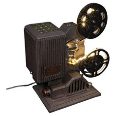 an old fashioned movie projector with lights on it's side and wheels attached to the front