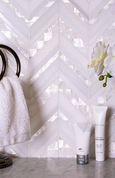 a white towel sitting on top of a counter next to a vase filled with flowers