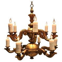 a chandelier with six lit candles hanging from it's center and four arms