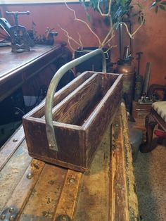 an old wooden box sitting on top of a table next to a potted plant