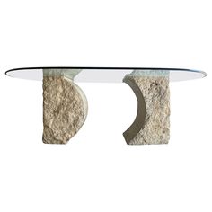 a glass and stone table with two curved bases on each side, against a white background