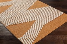 a brown and white rug on top of a wooden floor