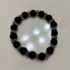 Matte black beaded bracelet with silver spacer beads. Additional silver beaded bracelet optional. The larger beads are 8mm round glass beads. The smaller beads are 5mm iron round beads. The bracelets are approximately 17-17.5 cm in length each. Black Beaded Bracelet, Black Beaded Bracelets, Silver Bead Bracelet, Bead Bracelets, Bead Designs, Black Beads, Spacer Beads, Silver Beads, Round Beads