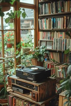 a record player sitting on top of a wooden box in front of a book shelf filled with books