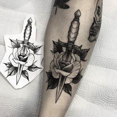 a tattoo on the leg of a person with a dagger and rose in it next to a skull