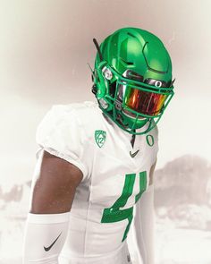 a football player wearing a green helmet and holding his hand on his hip while standing in the snow