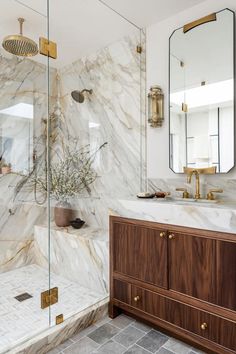 a bathroom with marble counter tops and wooden cabinetry, along with a walk in shower