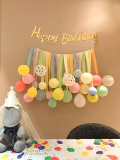 a teddy bear sitting in front of a birthday banner