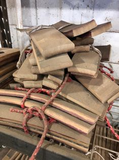 a pile of old books sitting on top of a wooden table covered in red string