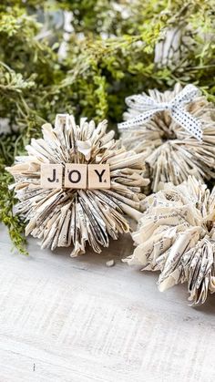 three paper flowers with the word joy spelled on them, sitting next to each other