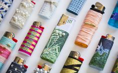 many different types of lighters are lined up on a white surface with beading