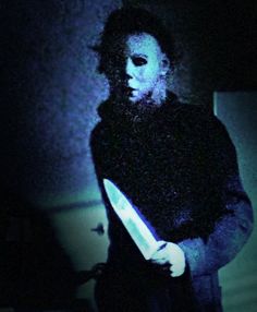 a man holding a knife in the dark