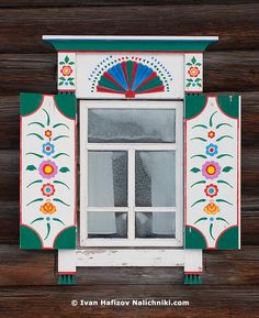 the window is decorated with colorful flowers and fan shaped windowsills on wooden walls