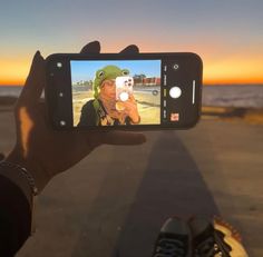 someone holding up their cell phone to take a selfie with the image of a person wearing a frog hat