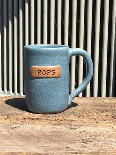 a blue coffee mug sitting on top of a wooden table