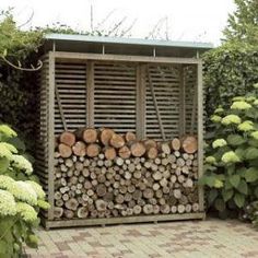 a garden shed with logs stacked in it