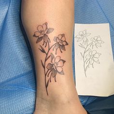 a tattoo on the leg of a woman with flowers