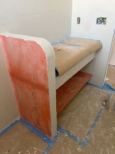 a room that has some kind of bench in the corner with paint all over it