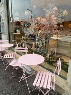 several pink chairs and tables in front of a store window