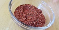 a glass bowl filled with spices on top of a wooden table