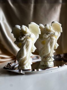 two white figurines are on a plate