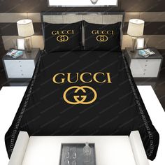 a bed with black and gold gucci logo on the comforter, pillows and lamps