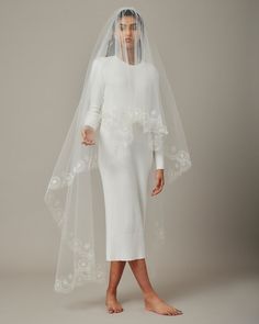 a woman in a white wedding dress and veil