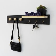 there is a key rack with keys on it and a purse hanging from the hook