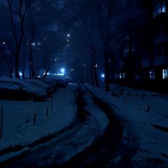 a city street at night covered in snow