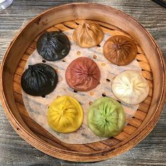 a wooden bowl filled with different types of dumplings