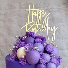 a birthday cake with purple flowers and eggs on it