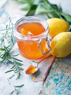 a glass jar filled with liquid next to lemons