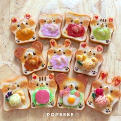 toasted bread shaped like cats and dogs with different toppings on them sitting on a wooden surface