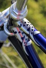 the handlebars on this bike are decorated with blue and white hearts, as well as an ornamental design