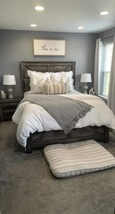 a large bed sitting in a bedroom on top of a carpeted floor next to two lamps