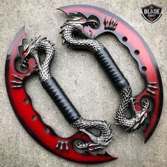 a red and black dragon handlebar cover with two swords attached to the end of it