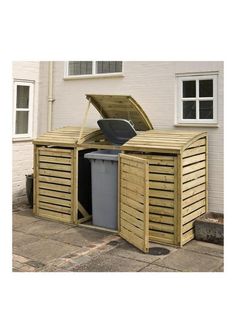 a wooden storage shed with the door open and trash can in it's center