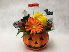 a pumpkin vase filled with flowers and decorations