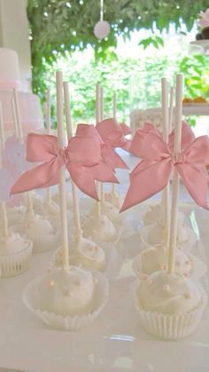 some cupcakes with pink bows are on a table