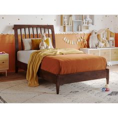 a bedroom with an orange bed and white dressers in the background is a child's room