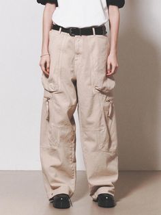 This is a comfortable cargo pants that is made out of sturdy cotton 100% fabric. With a unique cut pattern and wide adjustable silhouette with snaps on the hem, you can wear it for casual and daily outfit. - YKK zipper closure- Adjustable YKK snaps on the hem- Leather logo label detail- Wide silhouette Baggy Khaki Cargo Pants With Belt Loops, Beige Streetwear Bottoms With Multiple Pockets, Beige Cargo Jeans With Patch Pockets For Streetwear, Beige Cargo Style Pants For Streetwear, Beige Streetwear Pants With Patch Pockets, Beige Patch Pockets Pants For Streetwear, Beige Baggy Cargo Pants For Streetwear, Beige Baggy Cargo Jeans For Streetwear, Baggy Khaki Parachute Pants With Flap Pockets