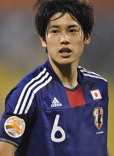 a young man with black hair wearing a soccer uniform