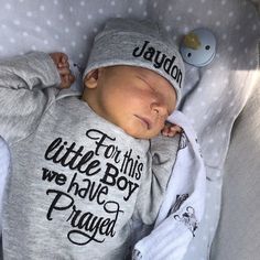 a baby sleeping in a bed wearing a hat