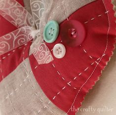 a red and white pillow with buttons on it