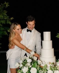 a bride and groom are cutting their wedding cake at the end of their night reception