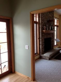 an empty living room with a fireplace and large windows