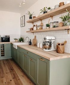 a kitchen with green cabinets and wooden counters