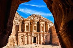 an arch in the side of a mountain with a building on it's sides